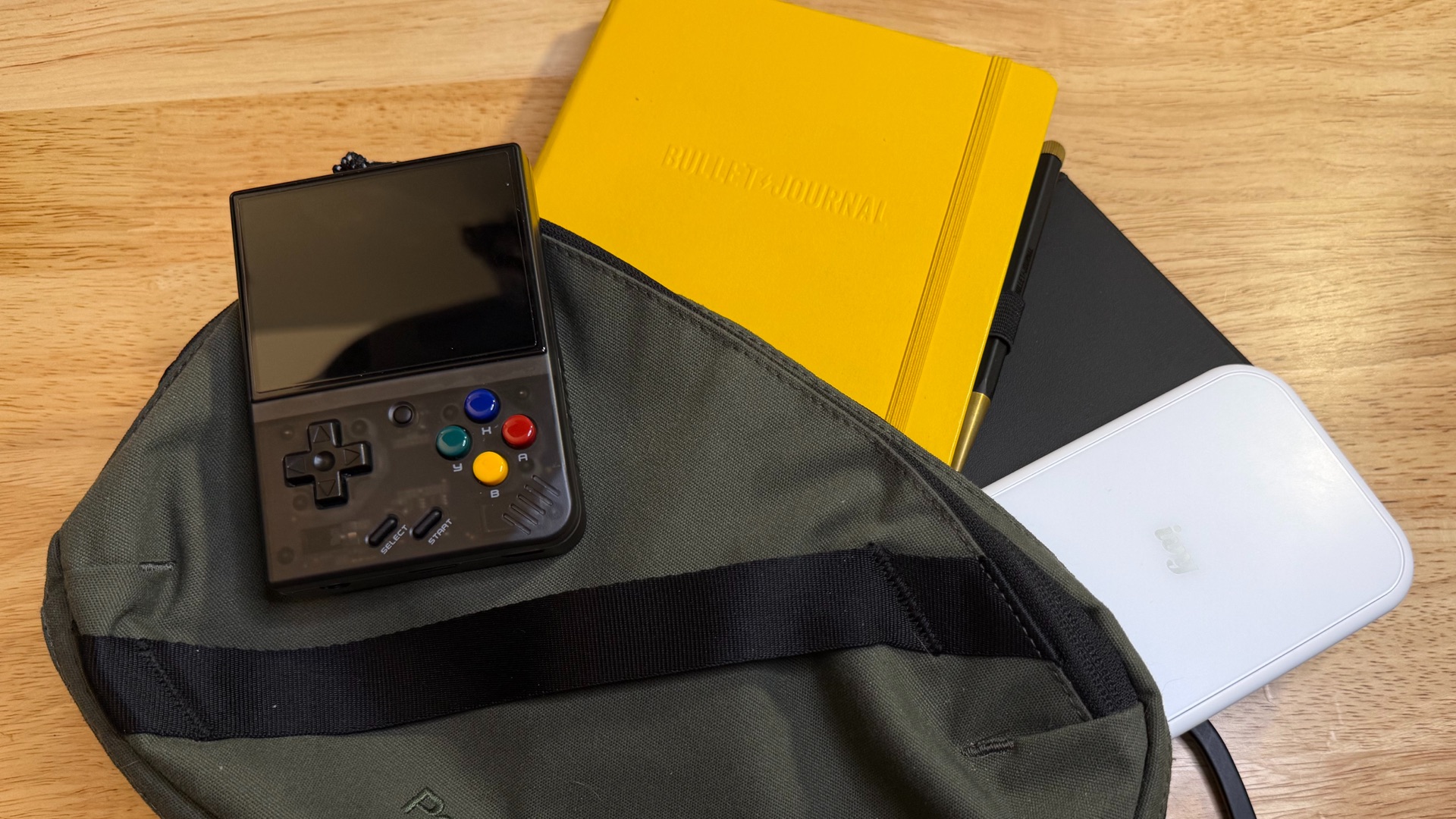 My carry sling with a journal, printer, ereader, and little gaming device.