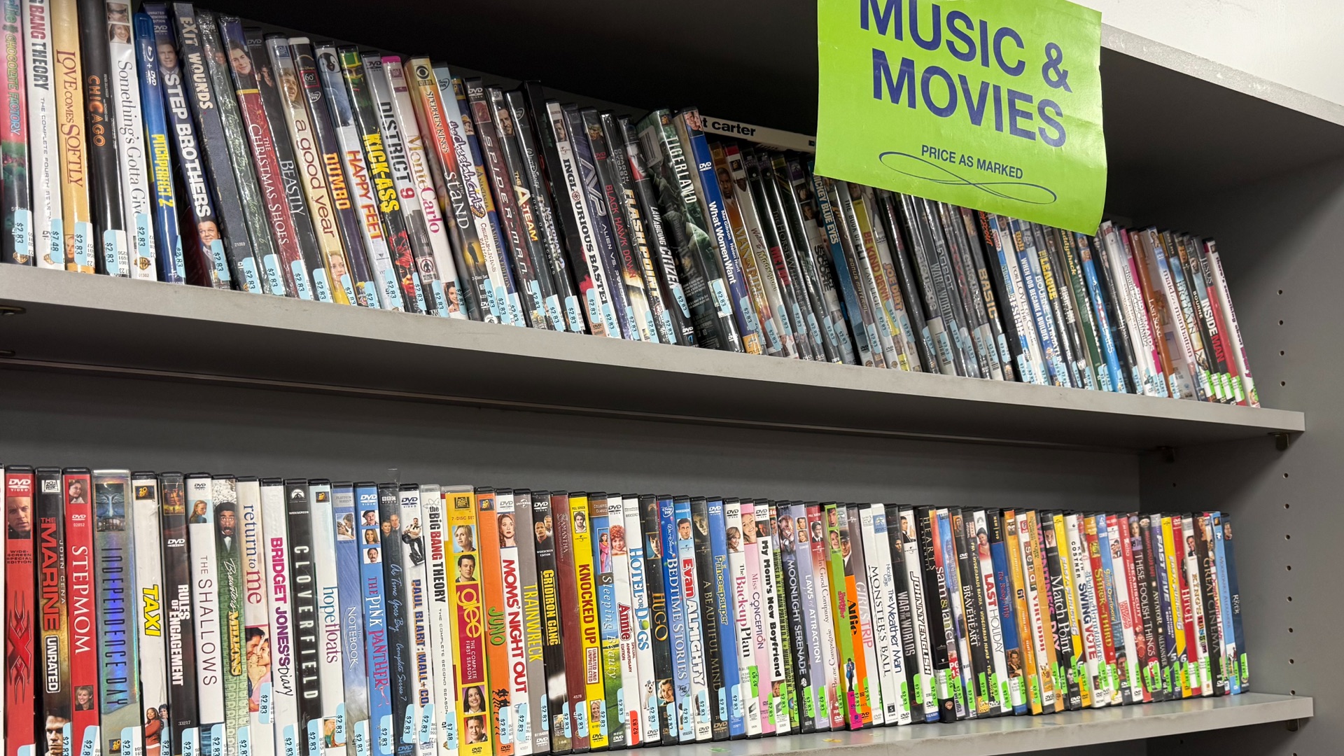 Several shelves full of movies at a thrift store